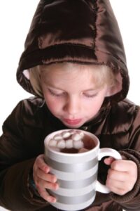 child holding hot coco